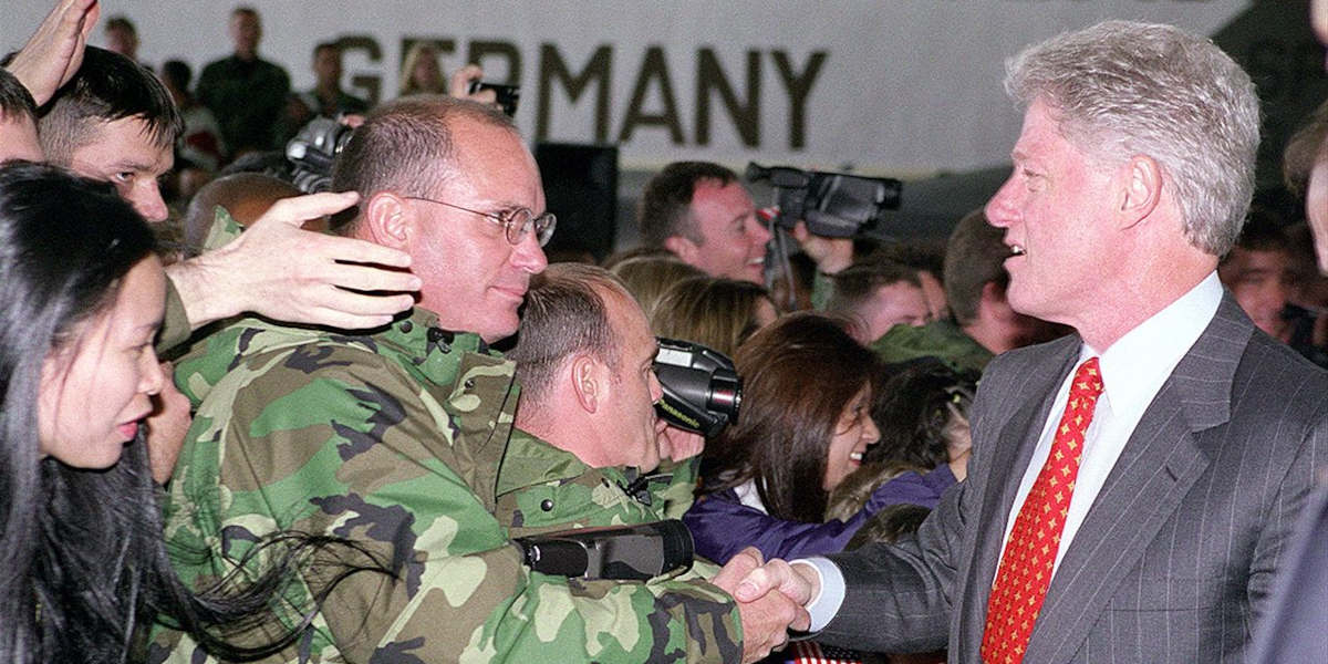 Former US President Bill Clinton (right) shaking hands with a man (left) at Spangdahlem Air Base, Germany