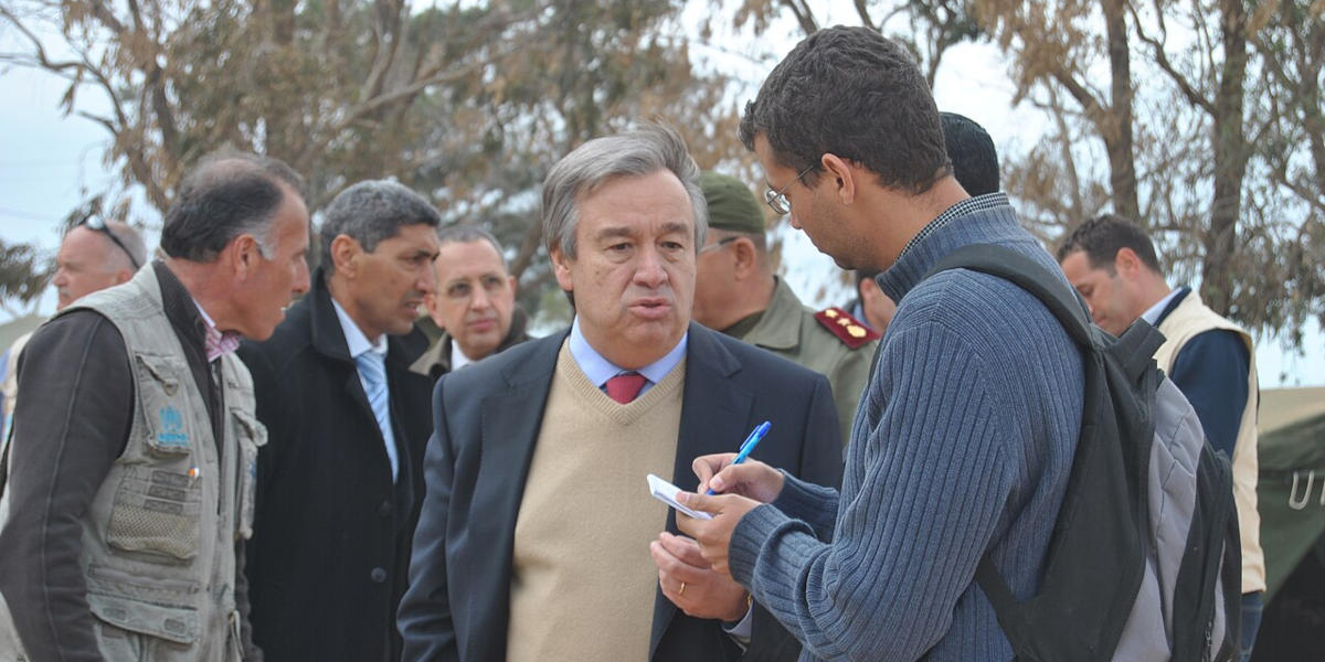 Former United Nations High Commissioner for Refugees António Guterres in southern Tunisia talking with a man in a blue jumper during the 2011 Libyan refugee crisis
