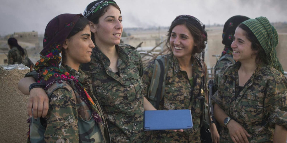 Four women Peoples' Defense Unit (YPG) fighters photographed together smiling
