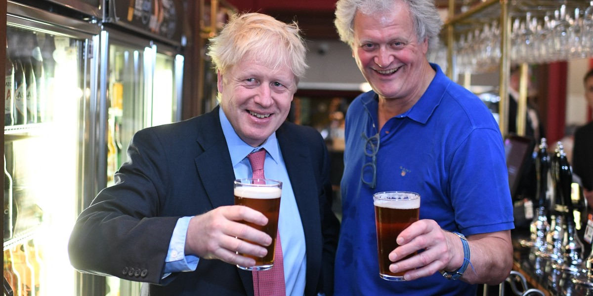 Prime Minister Boris Johnson and owner of Wetherspoons pub chain Tim Martin posing with pints of beer