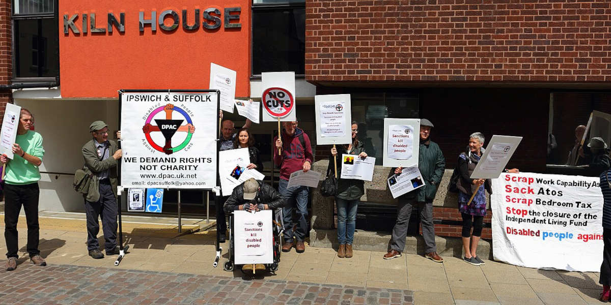 Members of Disabled People Against Cuts (DPAC) holding banners and placards protesting outside Norwich Jobcentre Plus