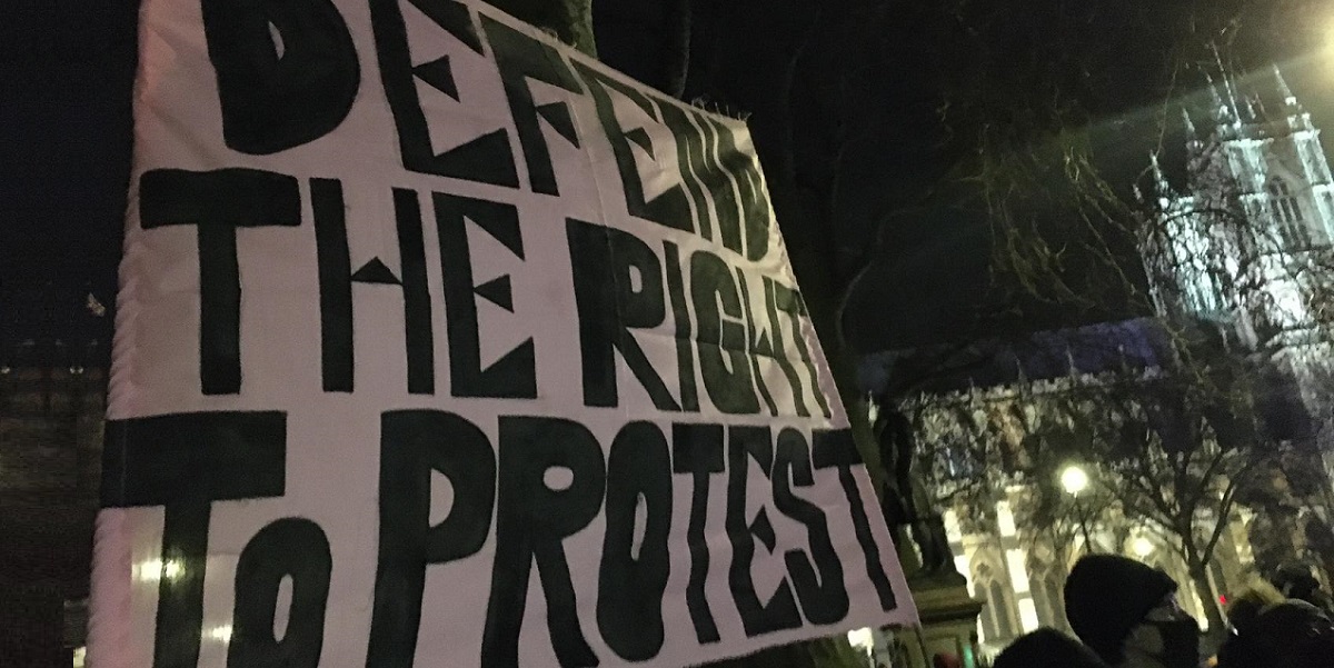 A protest banner reading Defend the right to Protest