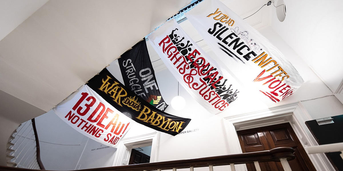 Banners draped across the exhibition ceiling read messages of equality and justice