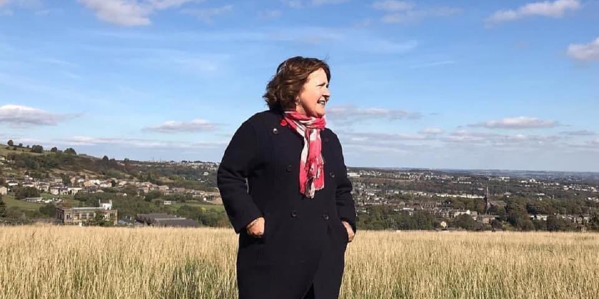 Photograph of Thelma Walker outdoors with a distant country view