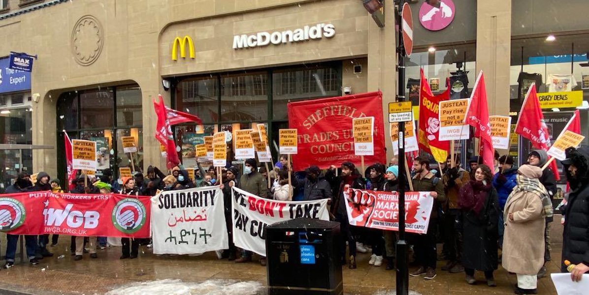 Stuart Delivery Workers strike in a large group outside a high street McDonalds