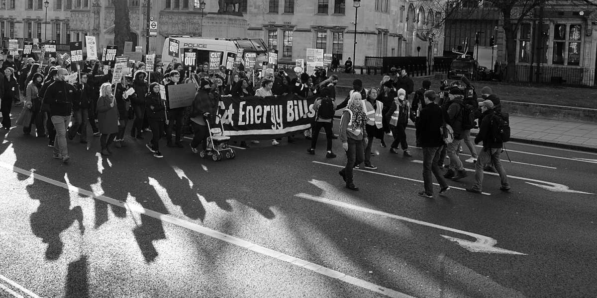 A black and white photo of a protest in London against the cost of living Crisis in 2022