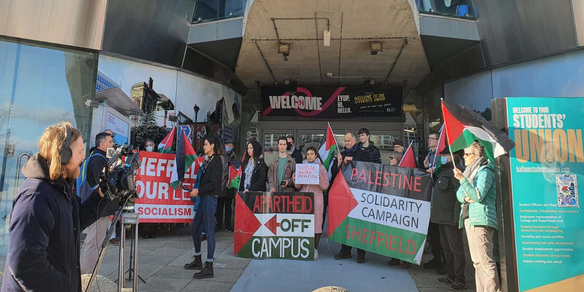 Rally at Sheffield Hallam University in response to the university's suspension of Shahd, featuring placards with slogans including 'Apartheid off campus' and the Palestine flag