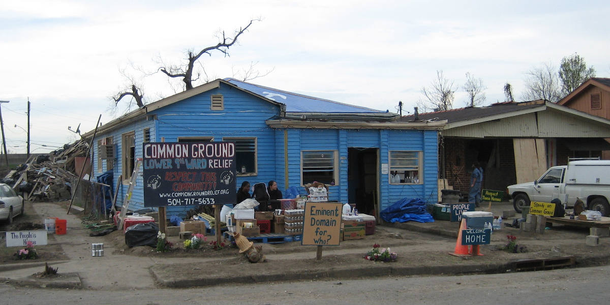 People sitting in front of a help station run by the Common Ground Collective mutual aid network in New Orleans, Louisiana