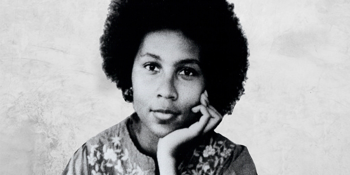 Black-and-white photo of a young bell hooks cupping her face in her hand