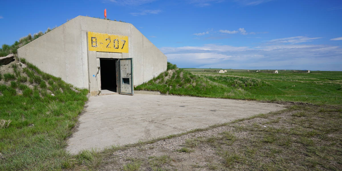 The entrance to the Bunker B-207 complex, its number displayed above the door, set against the South Dakota countryside