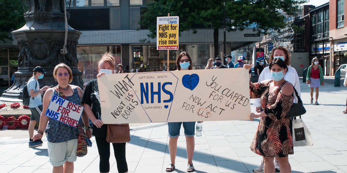 NHS workers at a socially distanced protest in Sheffield, holding signs asking for better pay