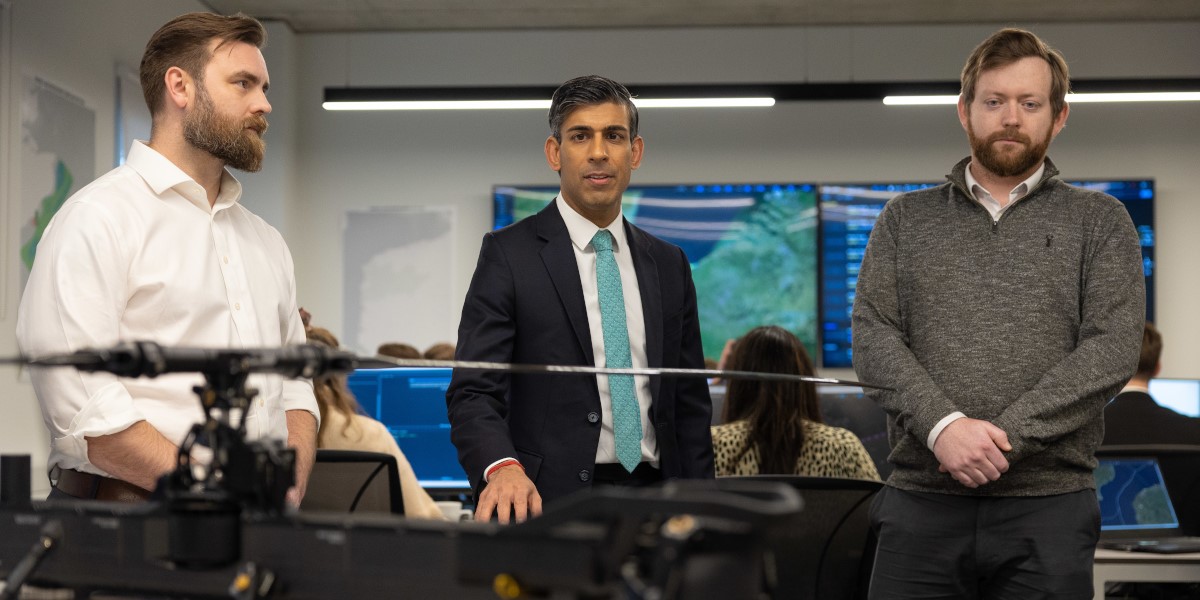 Rishi Sunak stands in an operations centre with two men.