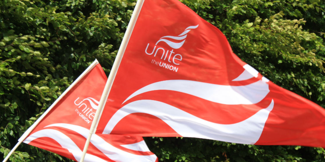 Two red flags which both have Unite the union's logo on them