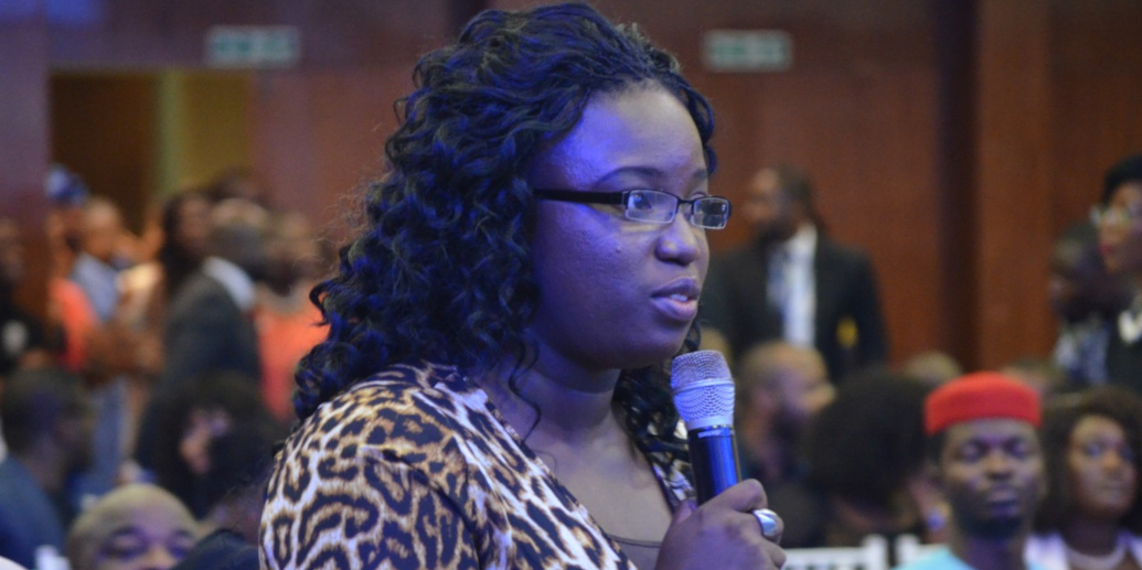 A woman speaks into a microphone at a Town Hall meeting for the Nigerian Election