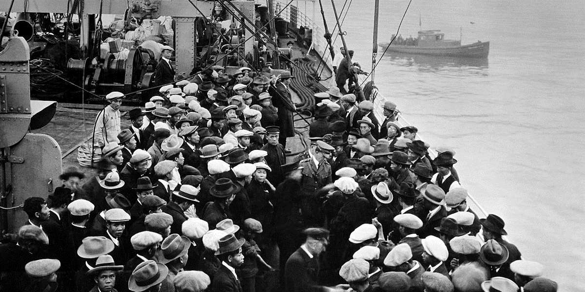 A black and white late-19th century photo of large crowds of people on a boat