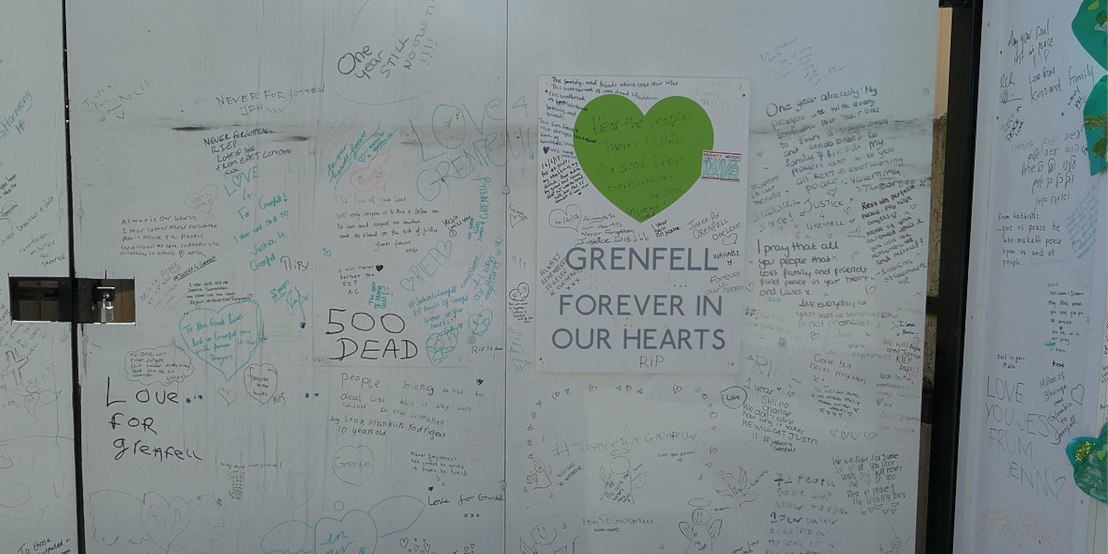 A poster is stuck on a wall that says 'Grenfell, forever in our hearts'. The wall is covered in handwritten notes.