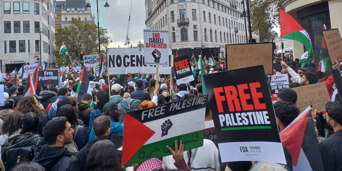 A demonstration in London. Many banners and placards are visible with messages including 'Free Palestine' and 'End Israeli Apartheid'