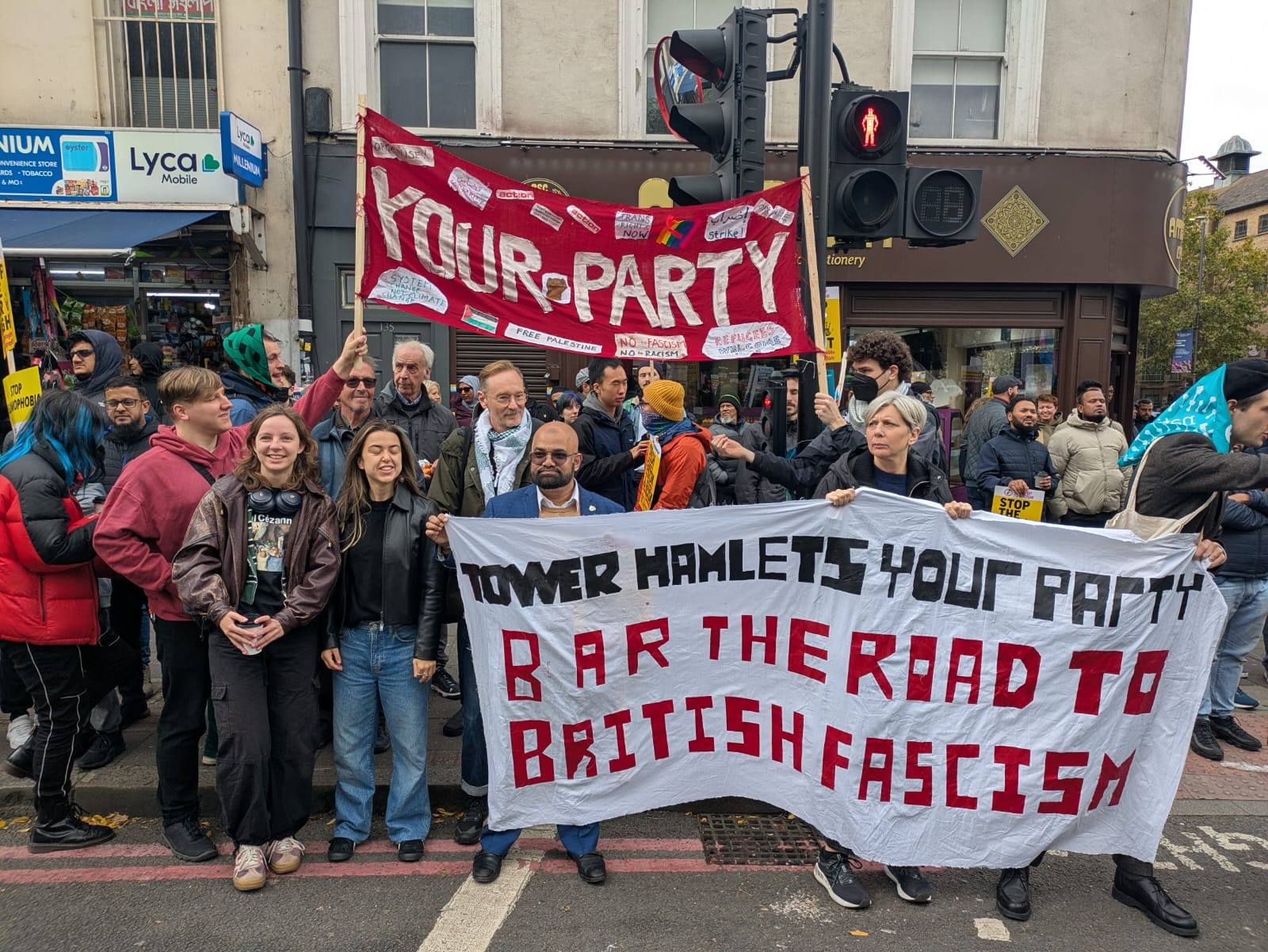 A group photo of members of Your Party's Tower Halmets group with anti-fascist banners