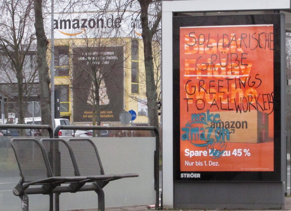 An advert for Amazon – in a bus stop in front of an Amazon building – has been graffitied to send solidarity to workers 