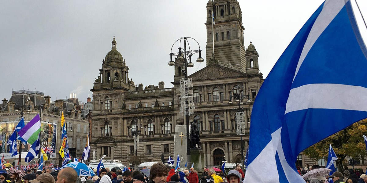 A crowd in George Square, Glasgow, waving Scottish flags