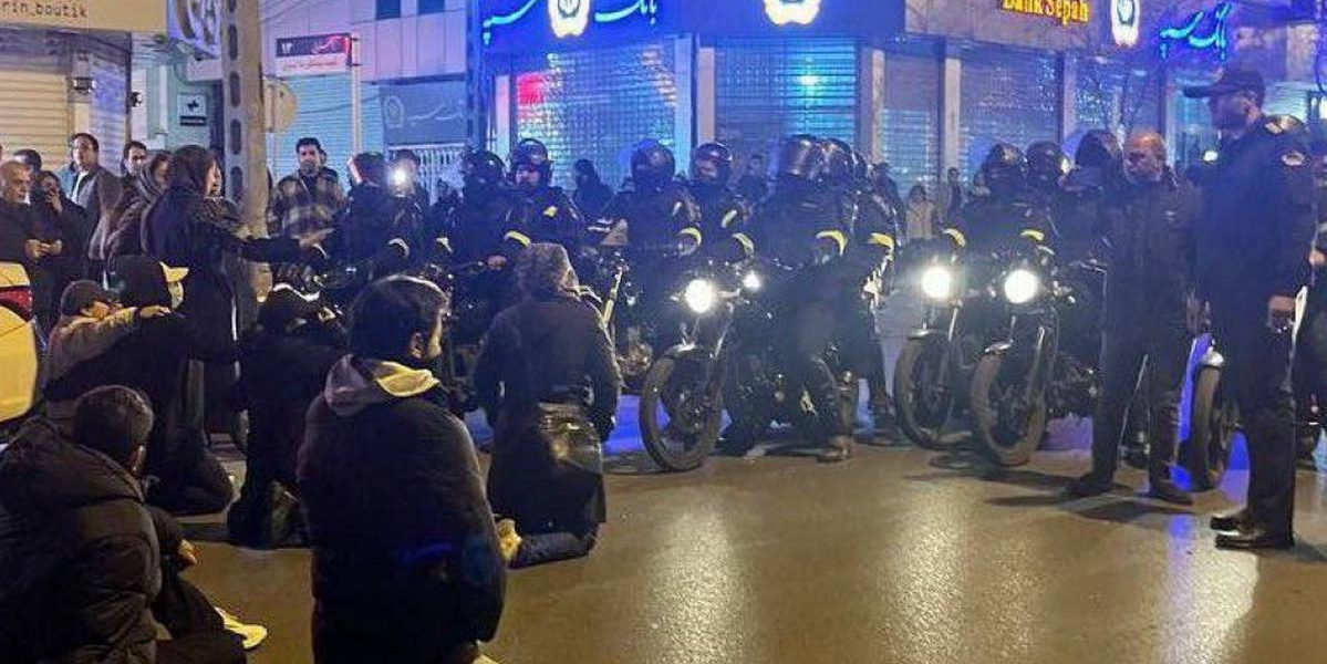 Kneeling protesters face off against police on motorbikes