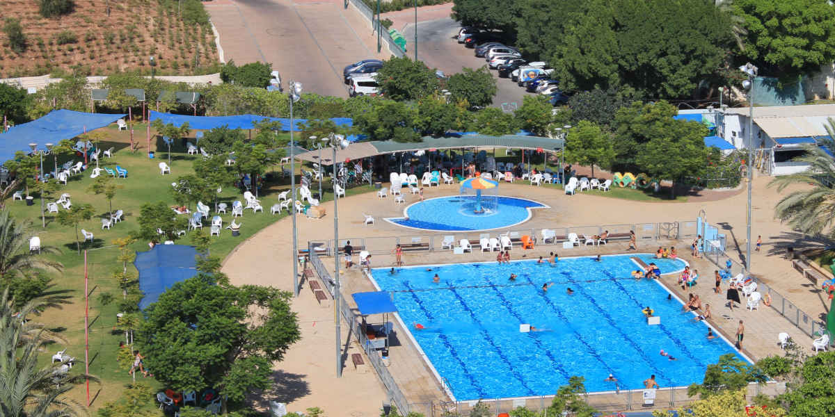 An aerial photograph of an Israeli settlement showing a large swimming pool
